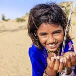 Girl drinking water in desert